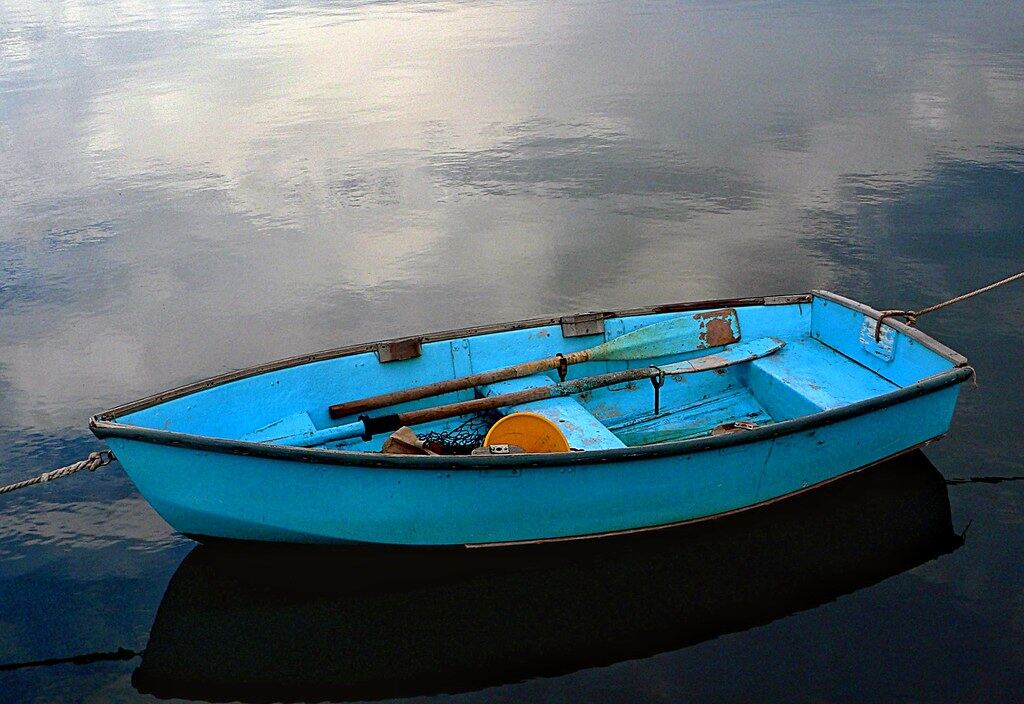 A small dinghy sitting on still water